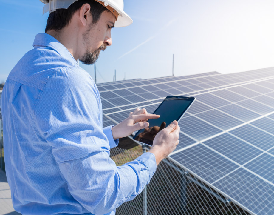 homem, olhando no tablet os resultados da captação de energia com as placas solares